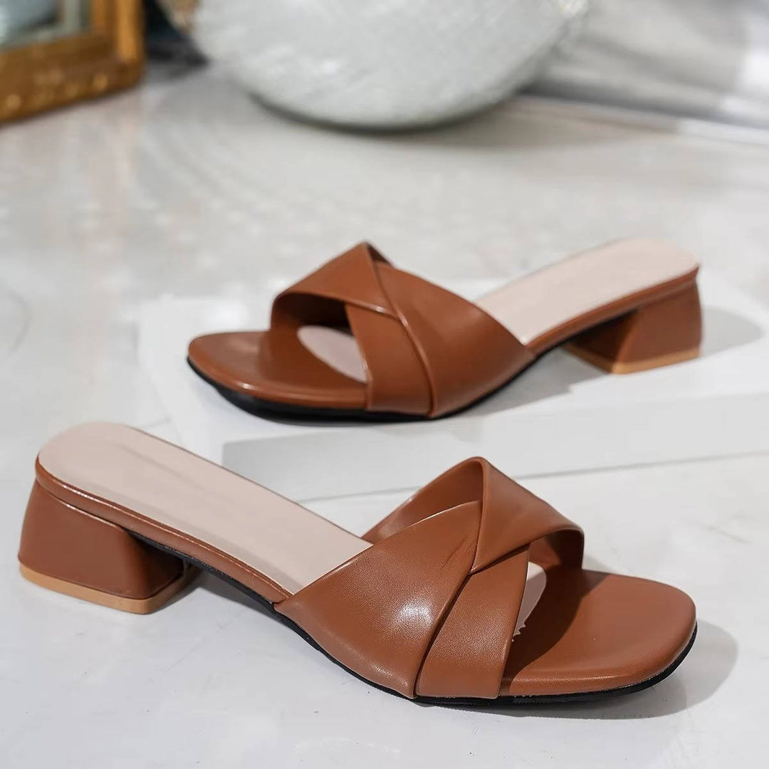 Elegant women's slide sandals featuring a sturdy block heel and fashionable cross straps.