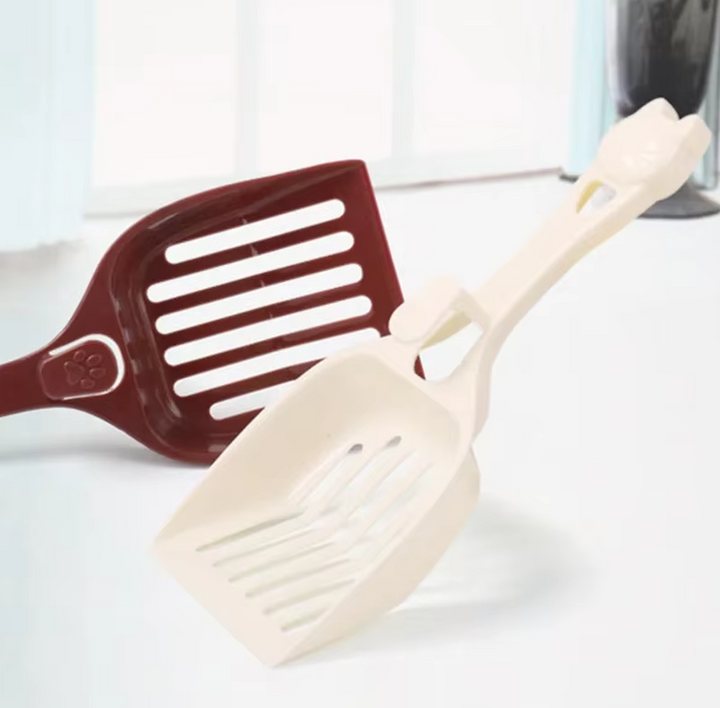 Close-up of cute cat head design on pink litter scoop handle, essential pet cleaning accessory