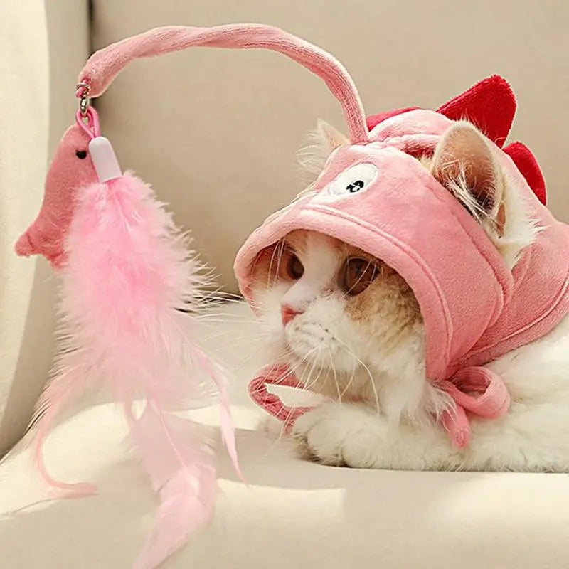 White cat wearing a plush pet hat, playing with the feather pendant, a fun cat toy.
