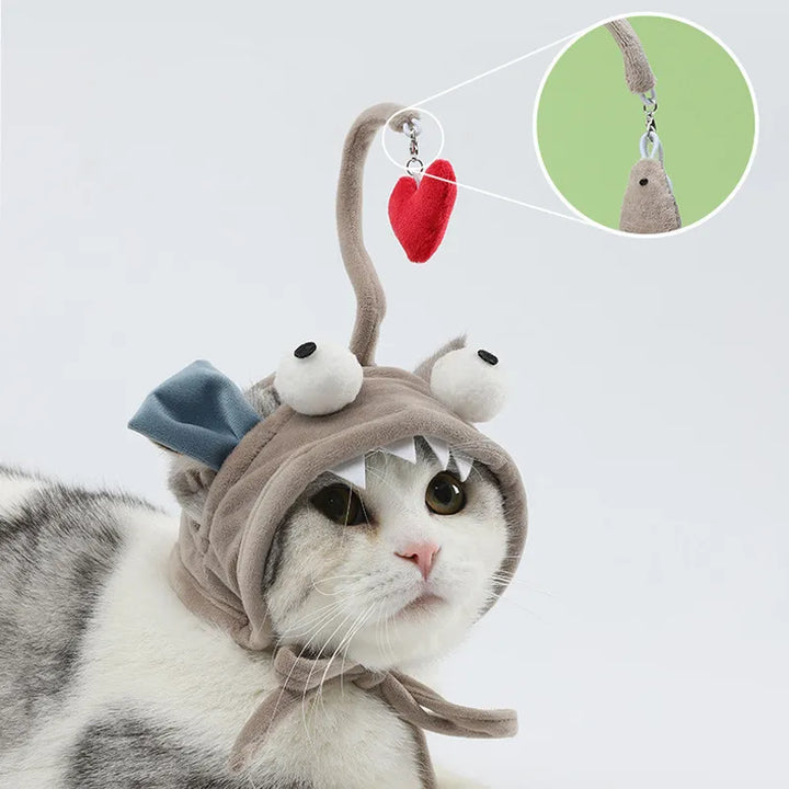 Adorable kitten with a cat costume hat featuring a dangling feather, perfect for playtime.