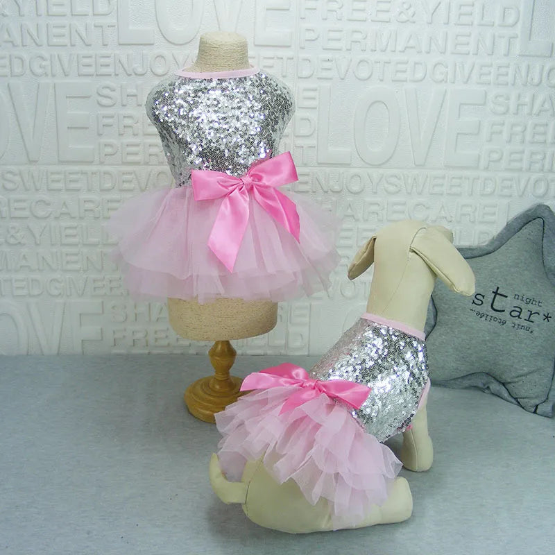 Small dog wearing a sparkly glitter tulle party dress with a matching hair bow, pet fashion item