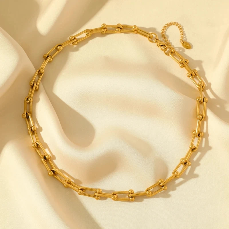 Model wearing a women's gold link chain necklace and bracelet set, showcasing elegant fashion jewelry.