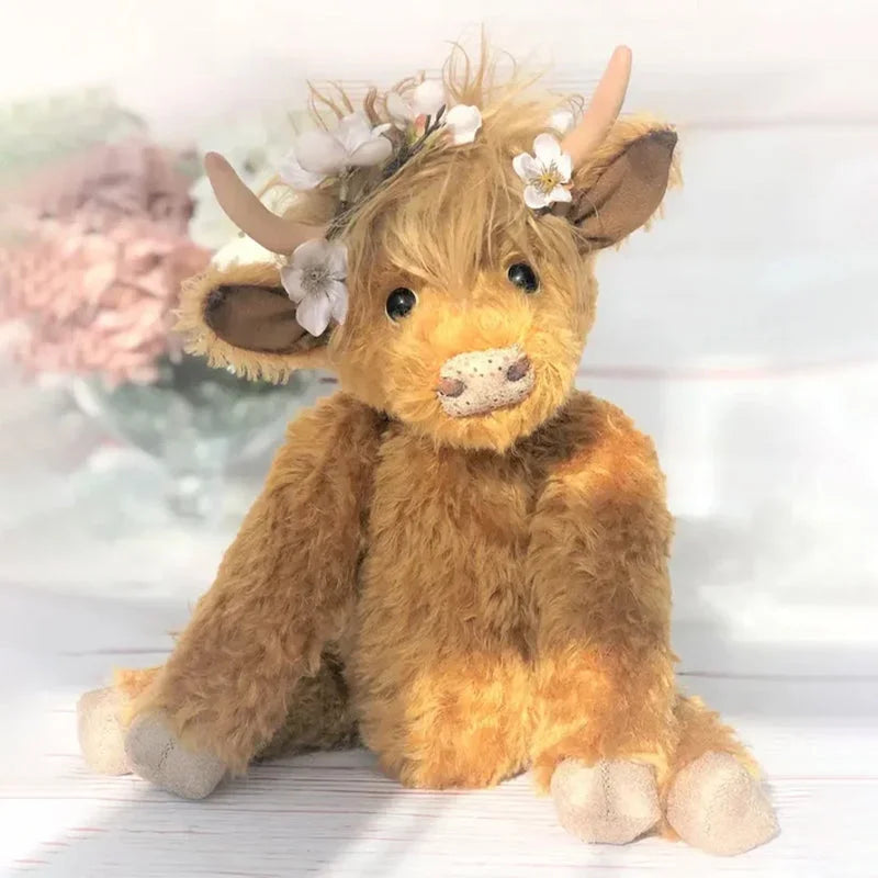 Handcrafted artisan Highland cow plush, a soft toy with a cute flower crown. Unique collectible farm animal.