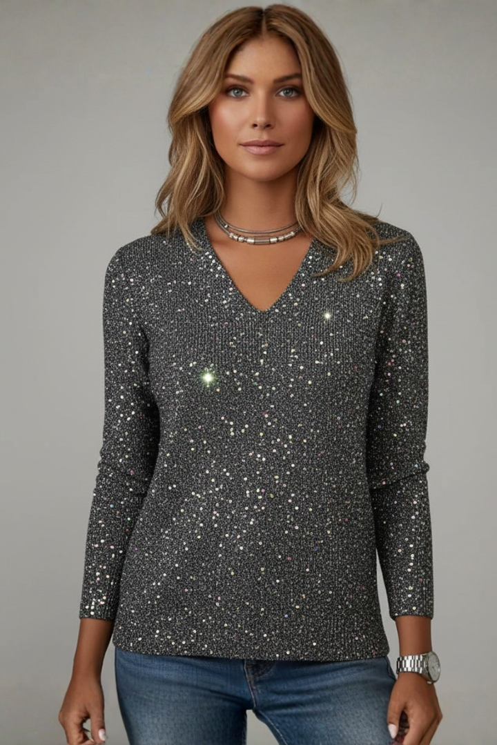 Close-up of dazzling sequin V-neck sweater, highlighting shimmer, texture, and elegant women's fashion.
