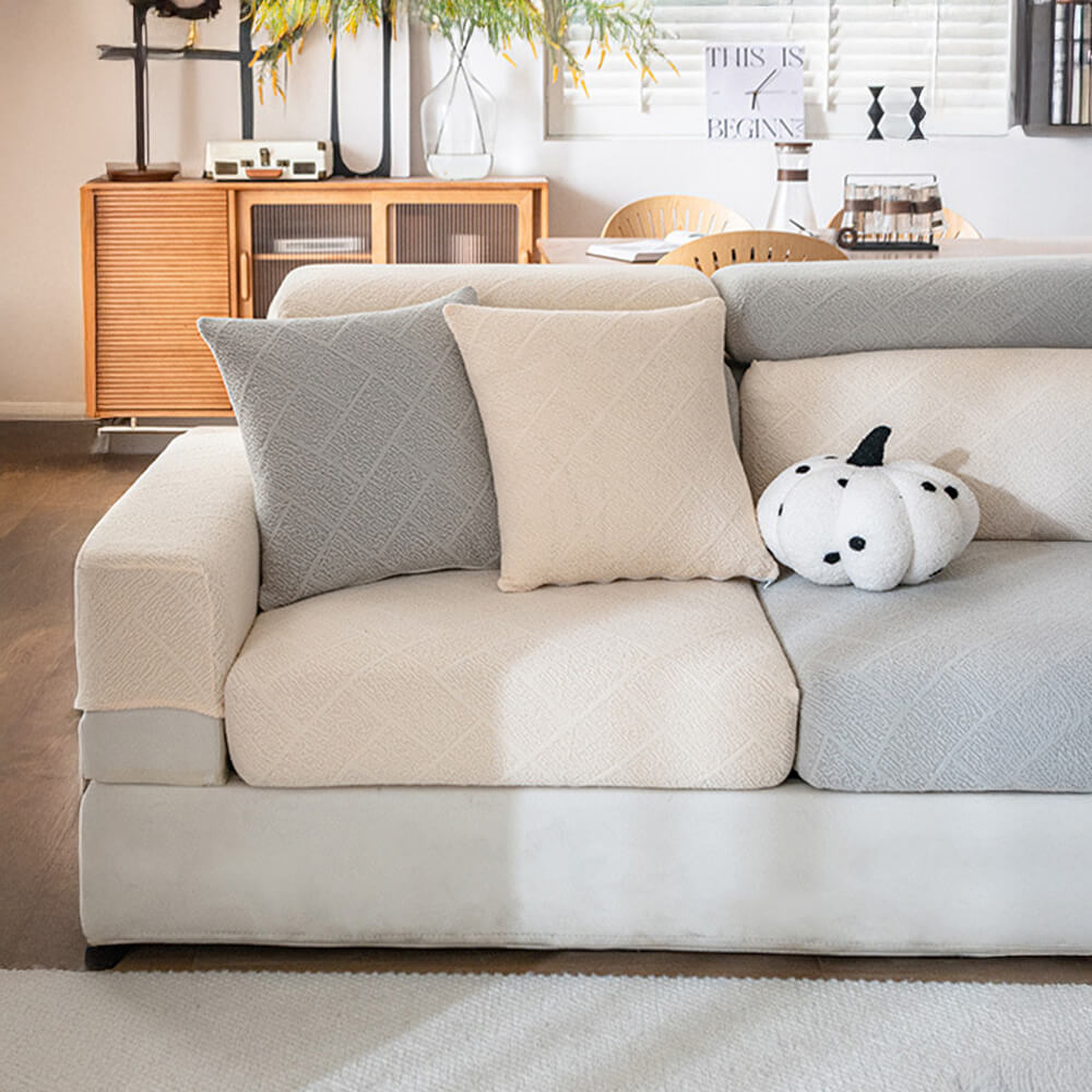 Stretch jacquard sofa protector draped over a couch, highlighting its full coverage and fit