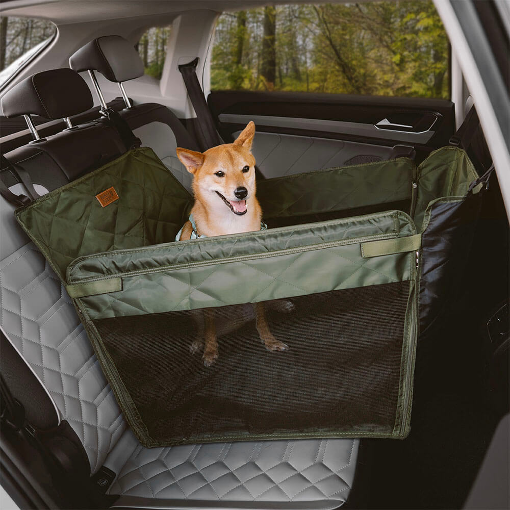Happy dog looking out window from a spacious dog car seat extender in the backseat.
