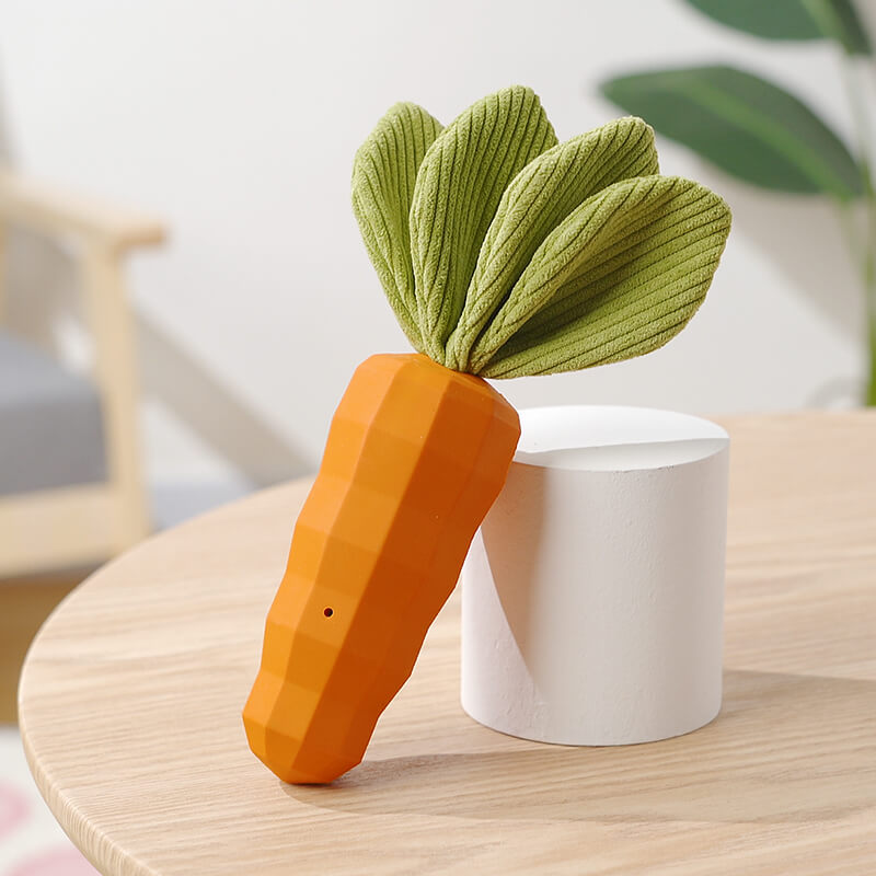 Puppy playfully biting a soft yet sturdy carrot-shaped squeaky dental chew toy.