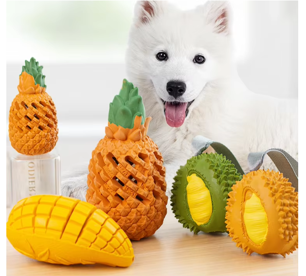 Dog chewing on a red apple-shaped rubber toy, promoting dental health and interactive play.