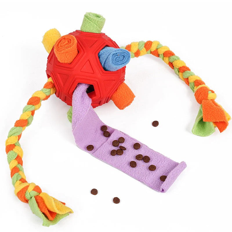 Close-up of a dog's nose sniffing a snuffle ball interactive treat dispenser toy