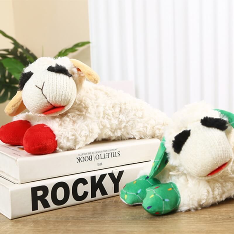 Puppy playing with a white plush lamb squeaker toy, an interactive and engaging dog toy