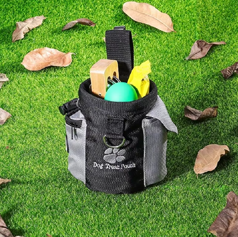 Black dog treat pouch with poop bag holder, perfect for outdoor dog training sessions.