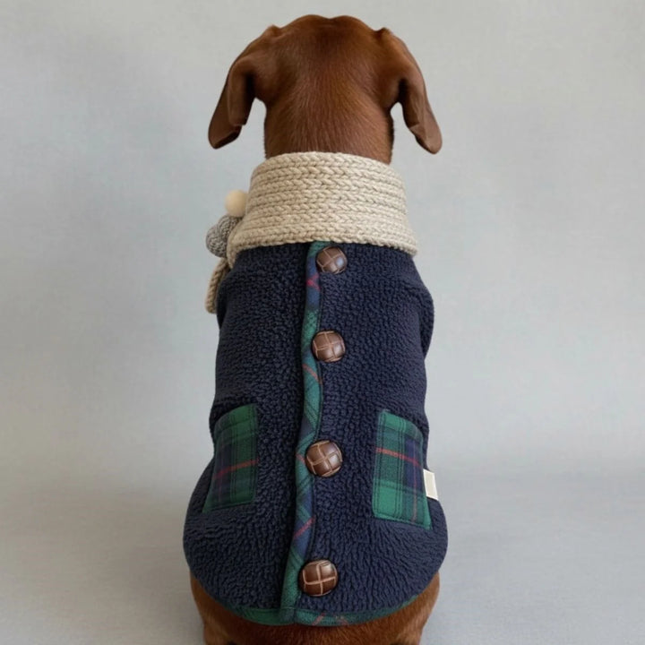 Close-up of the red plaid pattern on a dog's winter jacket with knitted scarf detail