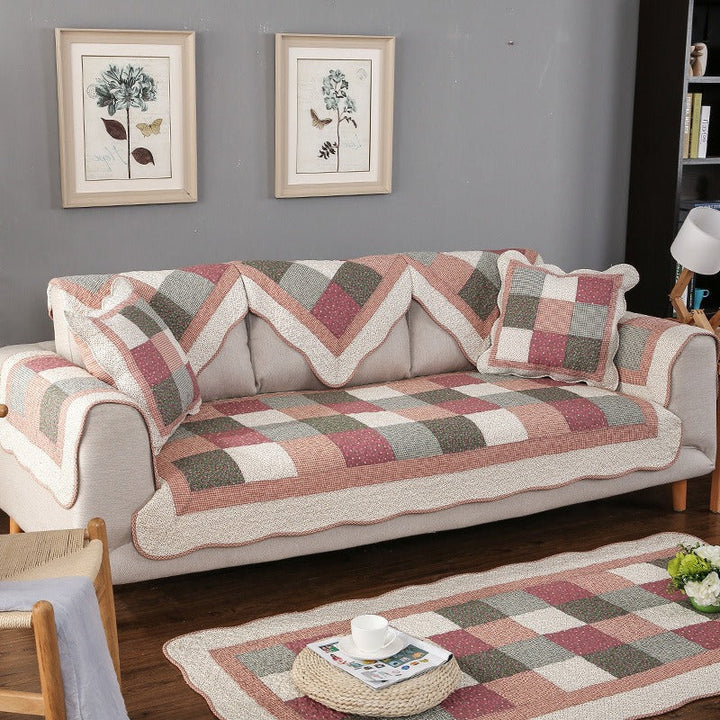 Non-slip quilted cotton sofa cover in a modern living room. Durable, washable furniture throw blanket.
