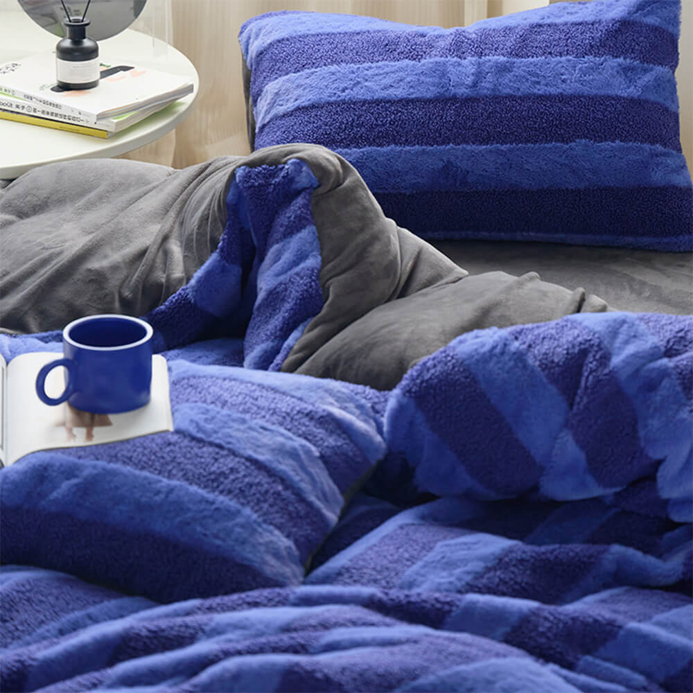 Striped dual-sided velvet and sherpa bed sheets, perfect for a cozy bedroom