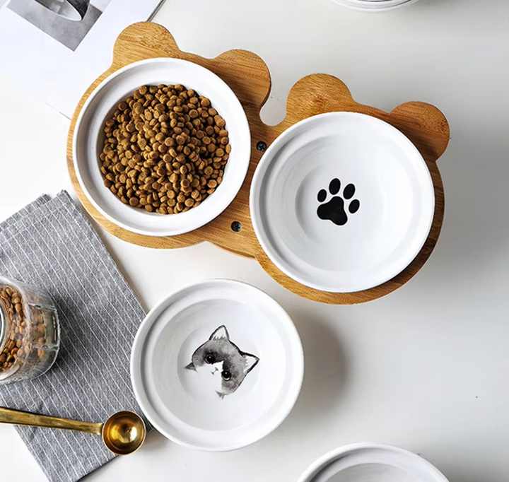 Compact elevated bamboo stand with two white ceramic bowls for cats, suitable for food and water.