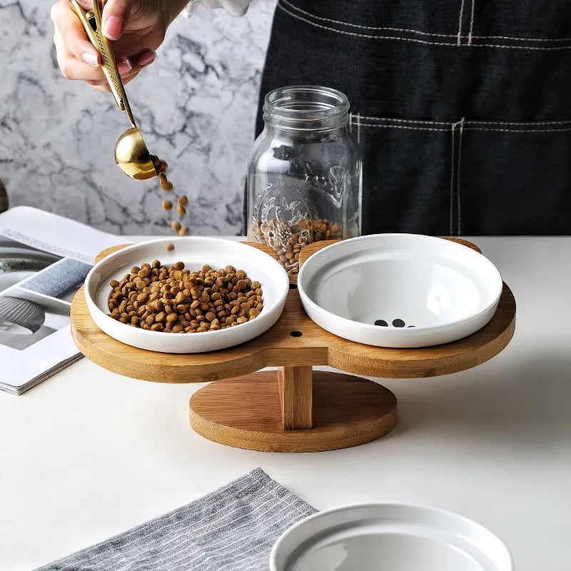 Elegant dual ceramic cat bowls on an elevated bamboo stand, ideal for comfortable feeding.
