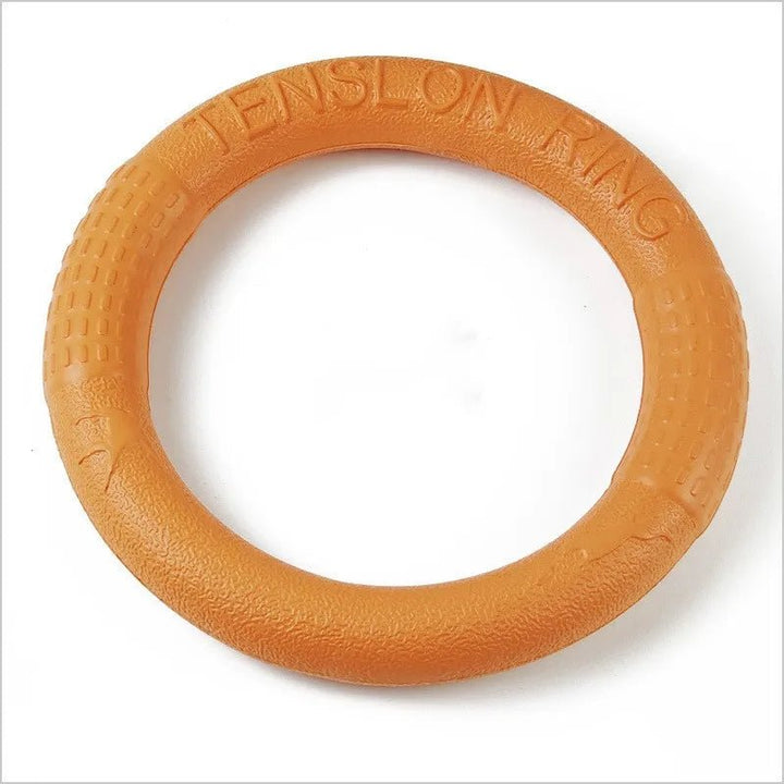 Puppy happily chewing on a small yellow dog training ring toy, soft yet tough for developing teeth.