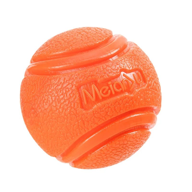 Close-up of a rubber dog chew ball showing its textured surface for dental cleaning and durability.