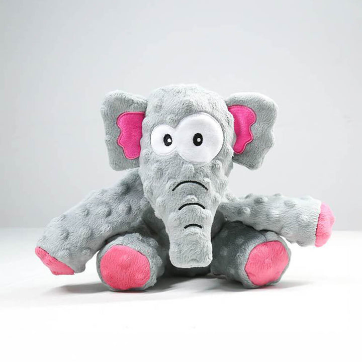 A dog happily chewing a tough squeaky elephant plush toy, demonstrating durability.