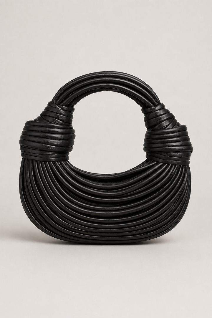 Silver crescent shoulder bag with unique sculptural loop handle. Elegant women's modern handbag for a stylish accessory.