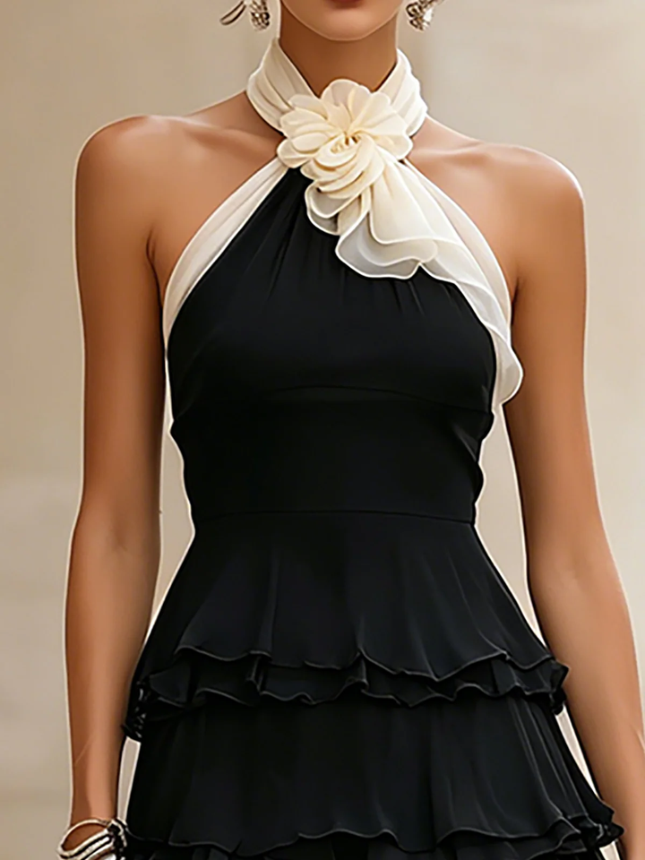 Women's black halter cocktail dress with elegant rosette & tiered ruffles. Ideal for evening events & date nights.