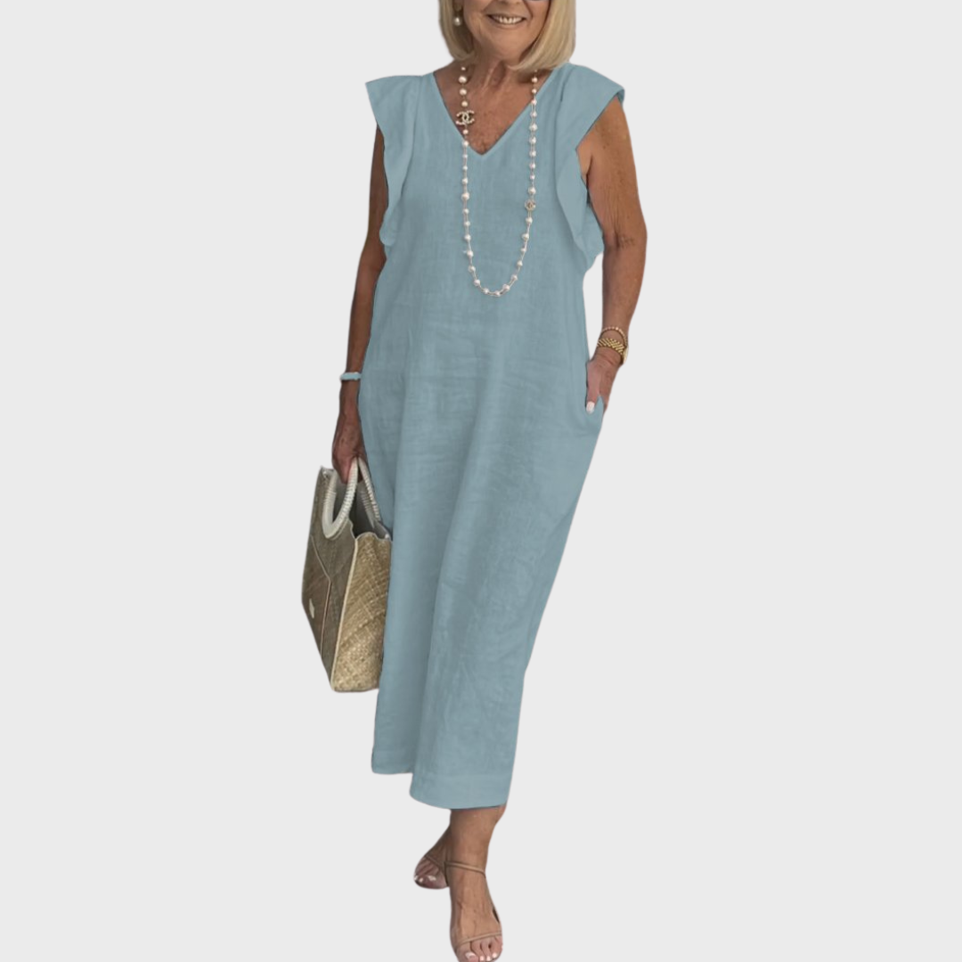 White women's flowy V-neck maxi dress with sleeveless cut, ruffle shoulders, and pockets, perfect for beach trips.