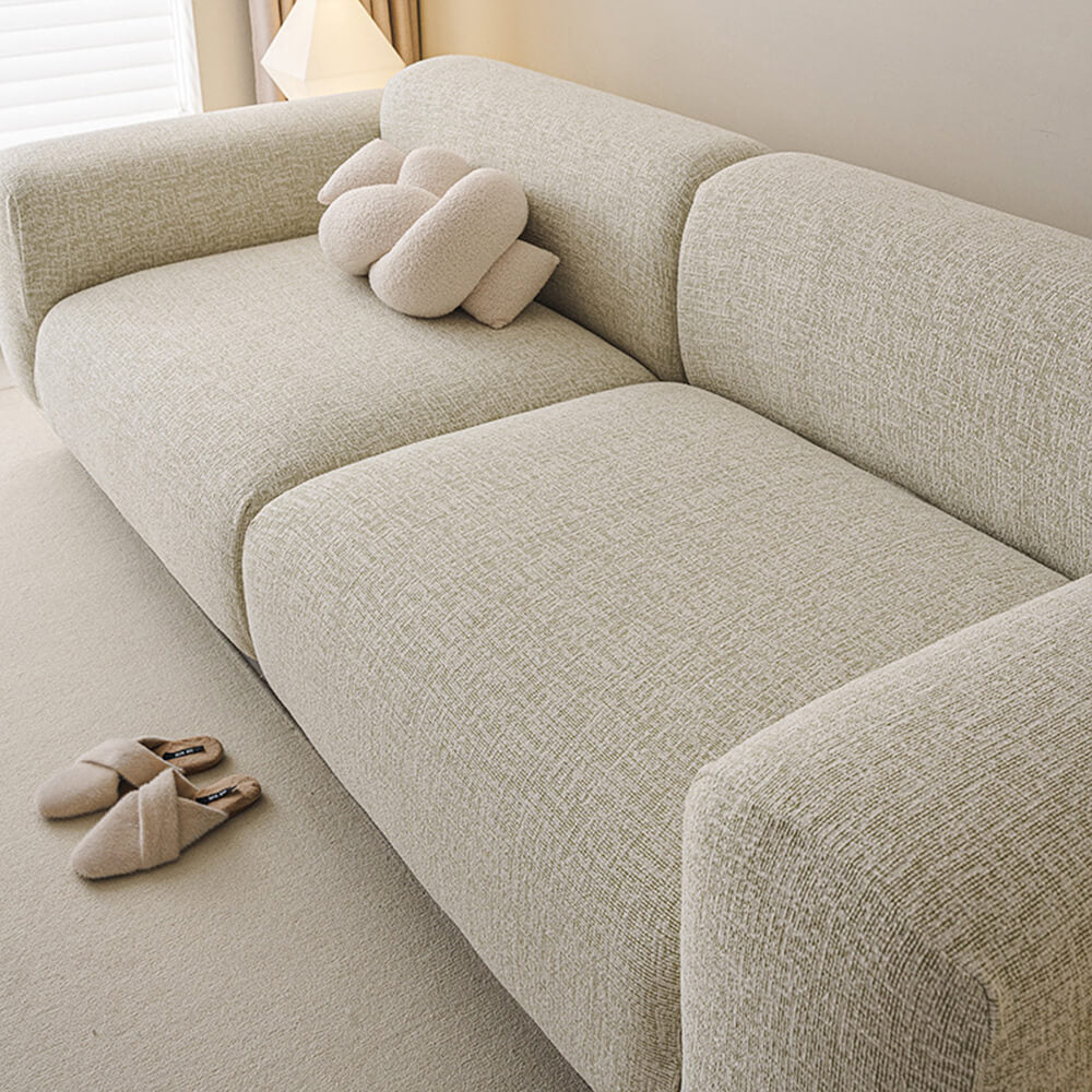 Close-up of chenille fabric on a stretch sofa cover, highlighting soft texture and durability