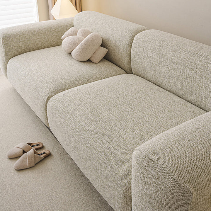Close-up of chenille fabric on a stretch sofa cover, highlighting soft texture and durability
