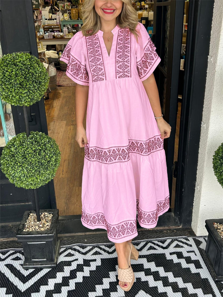 Woman in a stylish elegant embroidered boho midi dress, flowing A-line design, perfect for a relaxed summer day.