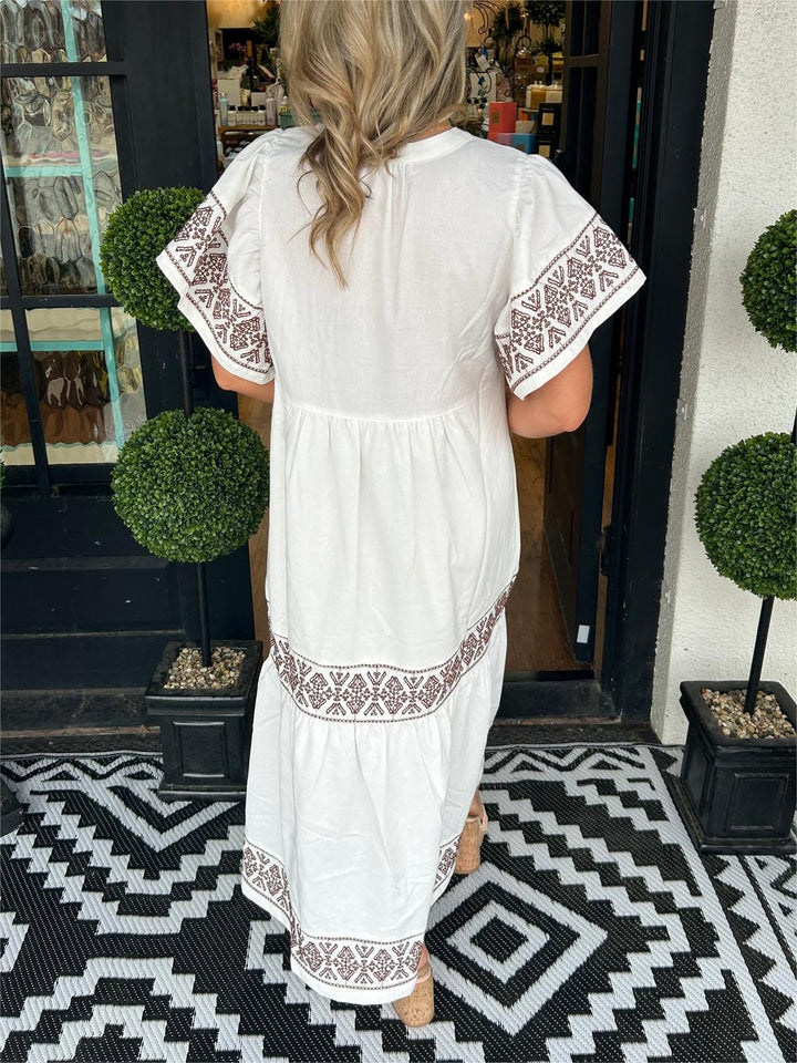 Side view of an elegant embroidered boho midi dress, showcasing its flattering A-line cut and long sleeve detail.