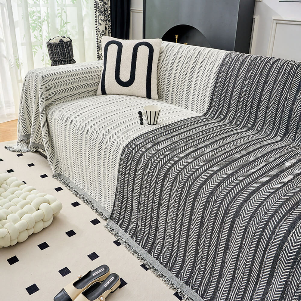 Multi-use throw blanket in elegant herringbone chenille, protecting a sofa with decorative style