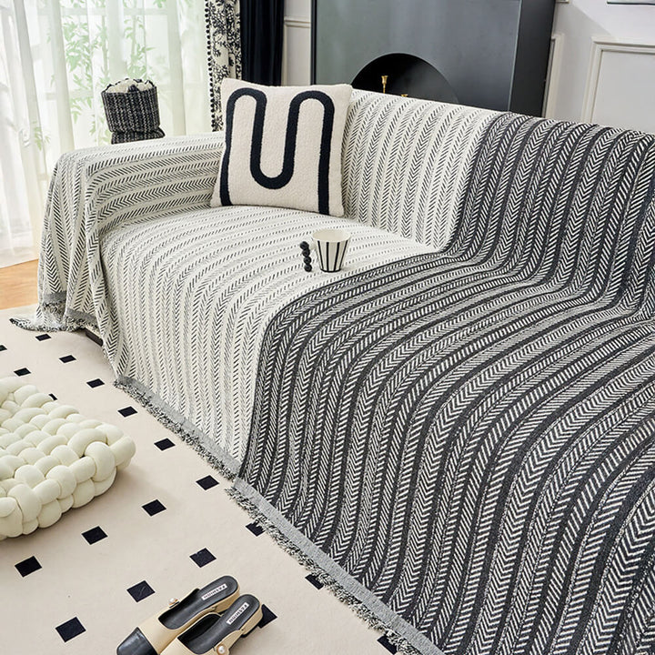 Multi-use throw blanket in elegant herringbone chenille, protecting a sofa with decorative style