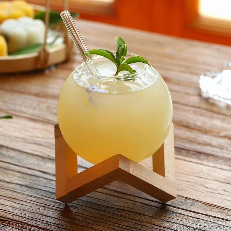 Elegant Moon Ball drinking glasses with a sturdy wood base, perfect for a home bar or unique kitchen decor.
