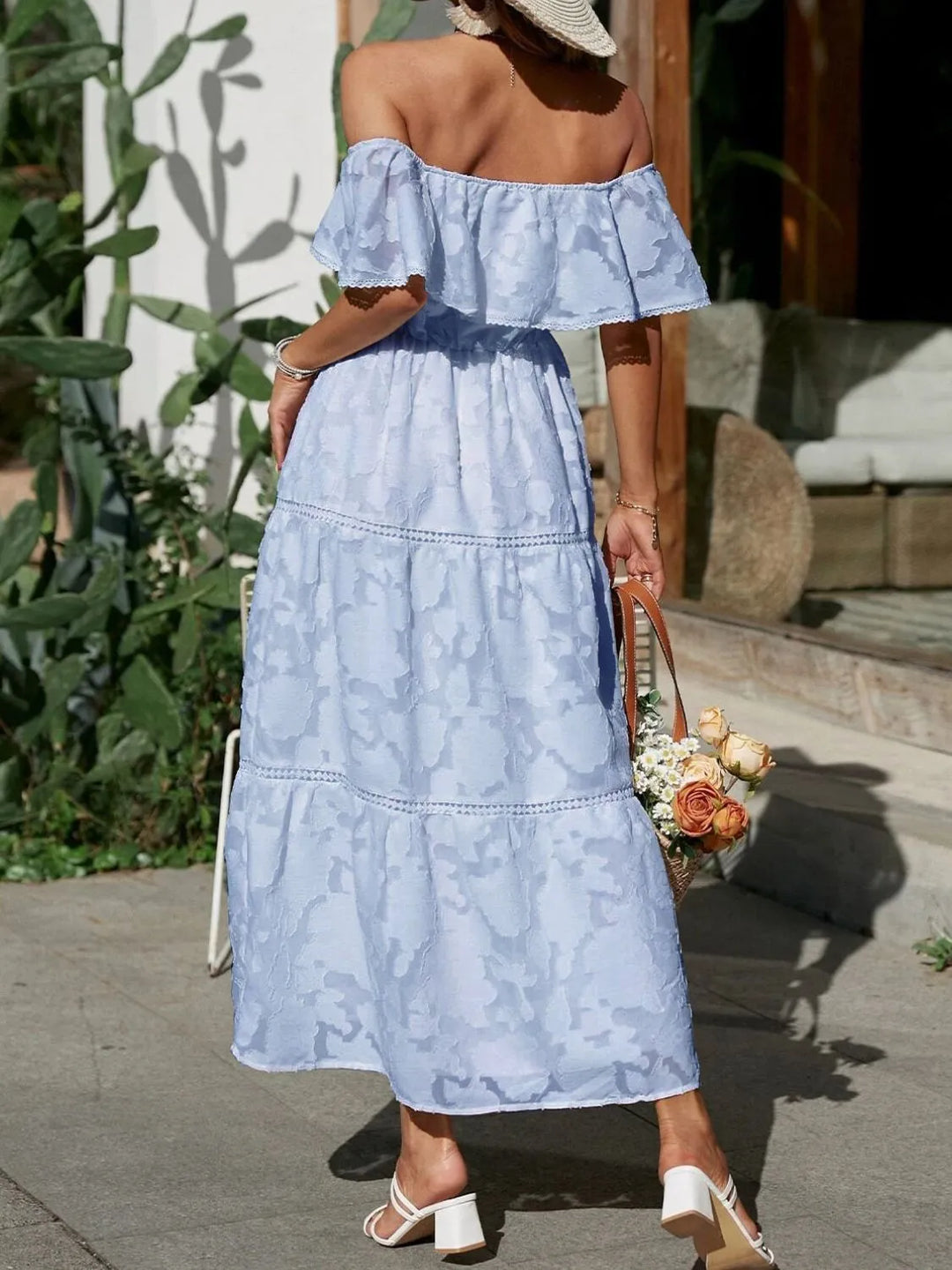 Detail view of the elegant tiered ruffles and off-shoulder design on a maxi dress.