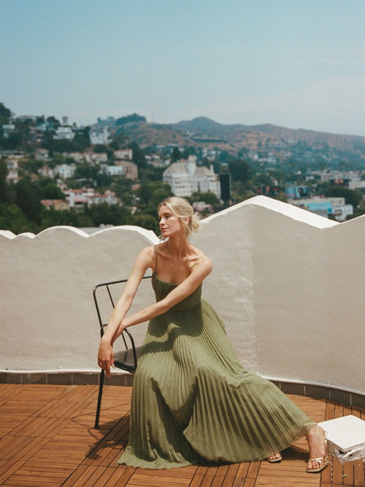Women's elegant olive green corset pleated maxi dress on a model, ideal for wedding guests & summer special occasions.