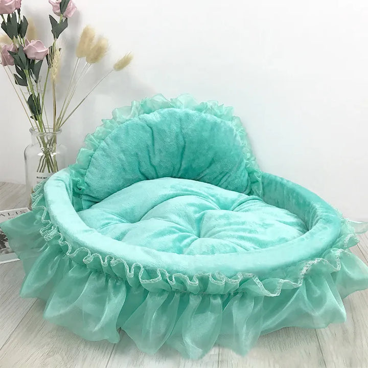 Elegant pink cat bed with tulle ruffle and a decorative bow, providing a cozy pet sleeping area.