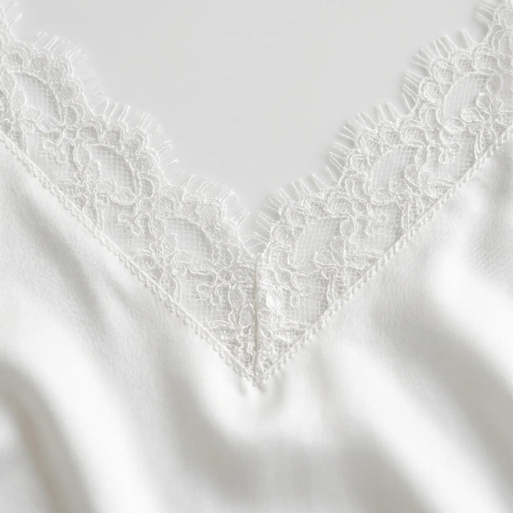 Chic women's white backless party dress; elegant mini length with spaghetti straps, ideal for summer evenings.