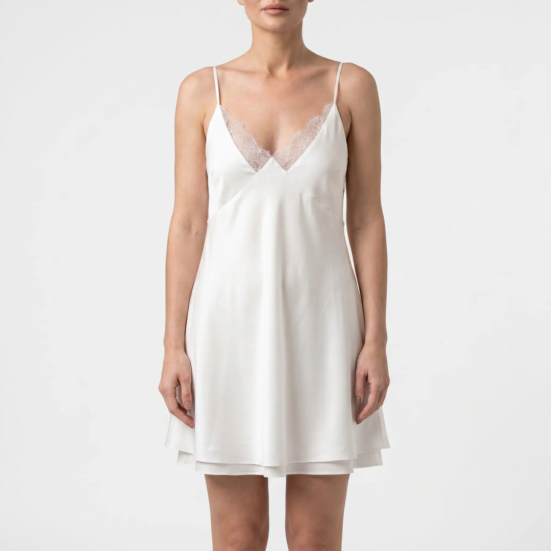 Stylish women's white mini dress featuring a backless design & delicate spaghetti straps, perfect for summer events.