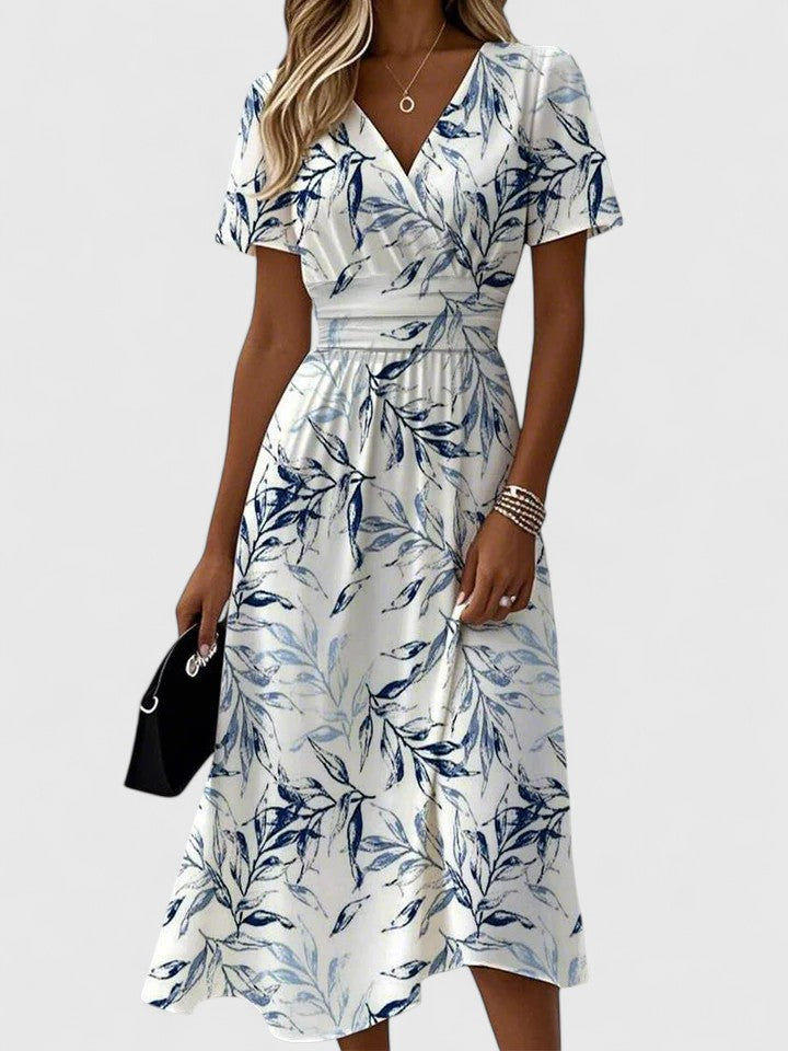 Elegant white botanical print midi dress for women, featuring flutter sleeves, V-neck, and elasticated waist. Summer style.