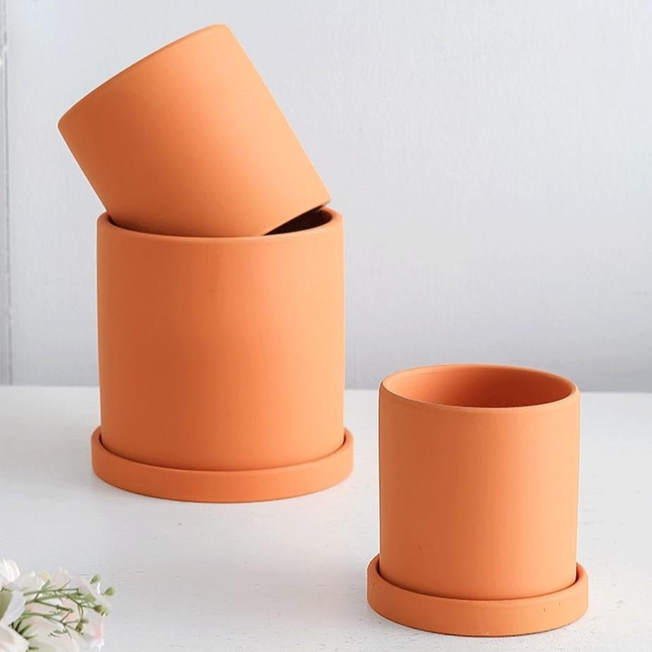 Modern ceramic flowerpot with a sleek design and protective saucer.