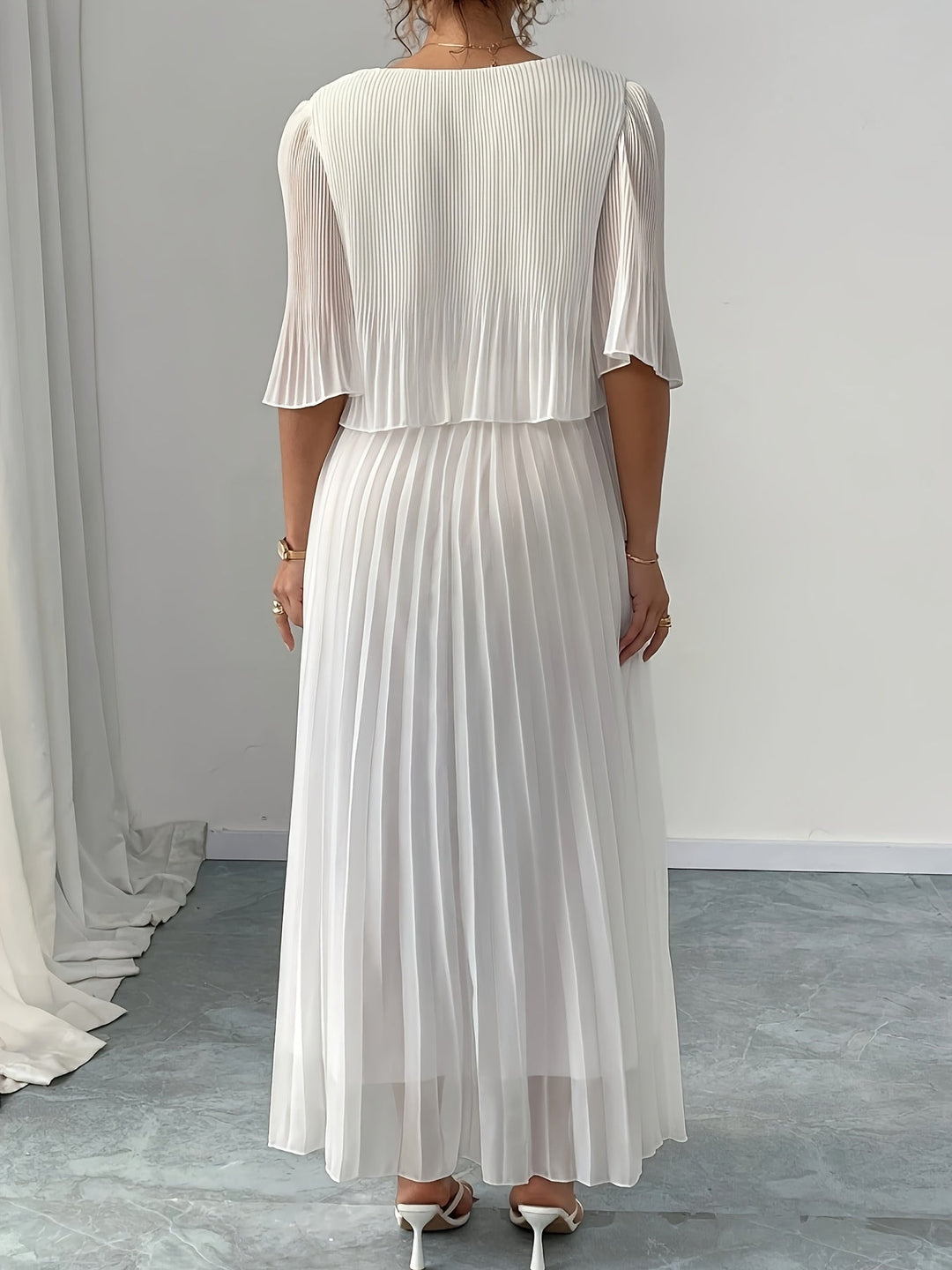 Women's white pleated maxi dress, elegant and flowy, ideal for wedding guests & special occasions.