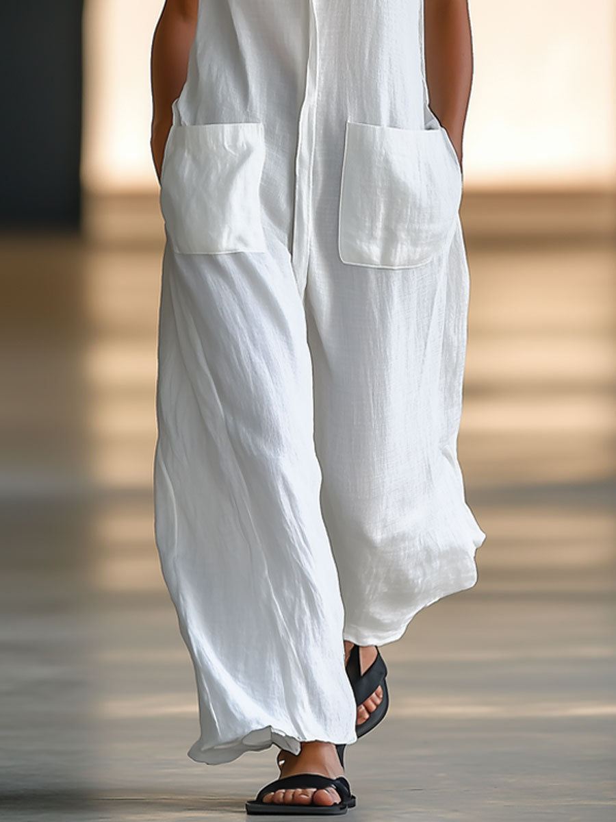 Stylish women's white V-neck sleeveless jumpsuit with a relaxed wide-leg silhouette and front patch pockets for resort wear.