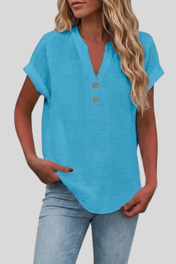 Woman in a crisp white V-neck short sleeve button blouse. Styled for a polished, professional office look.
