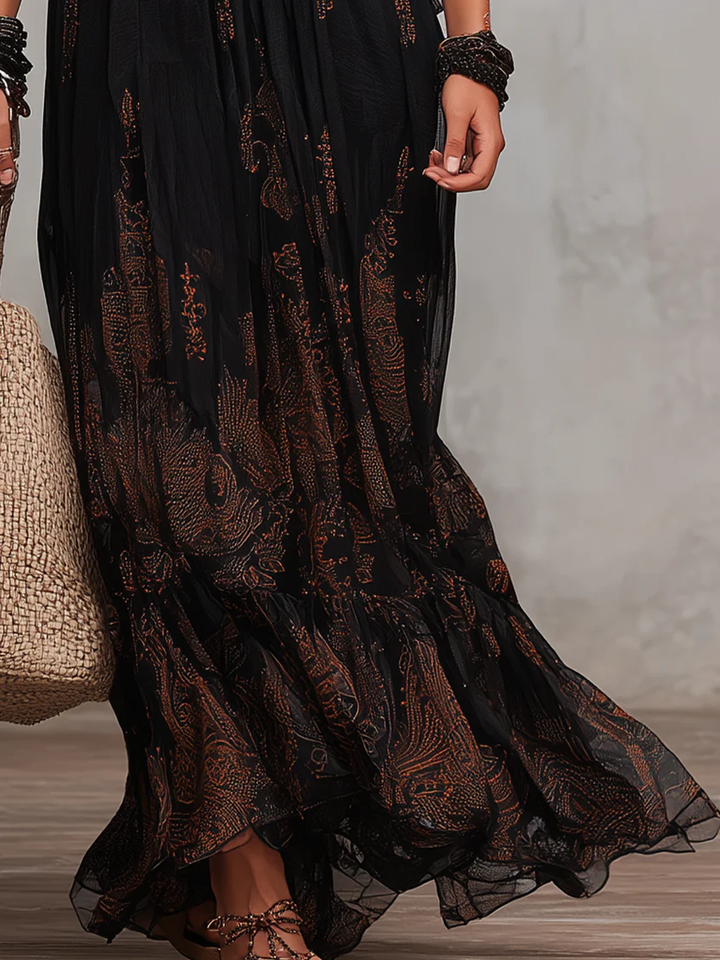Flowing black elegant boho maxi dress with beautiful lace accents and flutter sleeves, versatile for summer or evening.