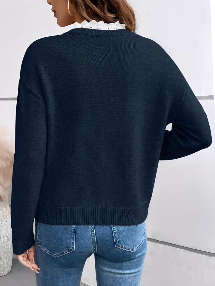 Close-up of feminine grey V-neck pullover sweater, highlighting the intricate lace trim detail around the neckline.
