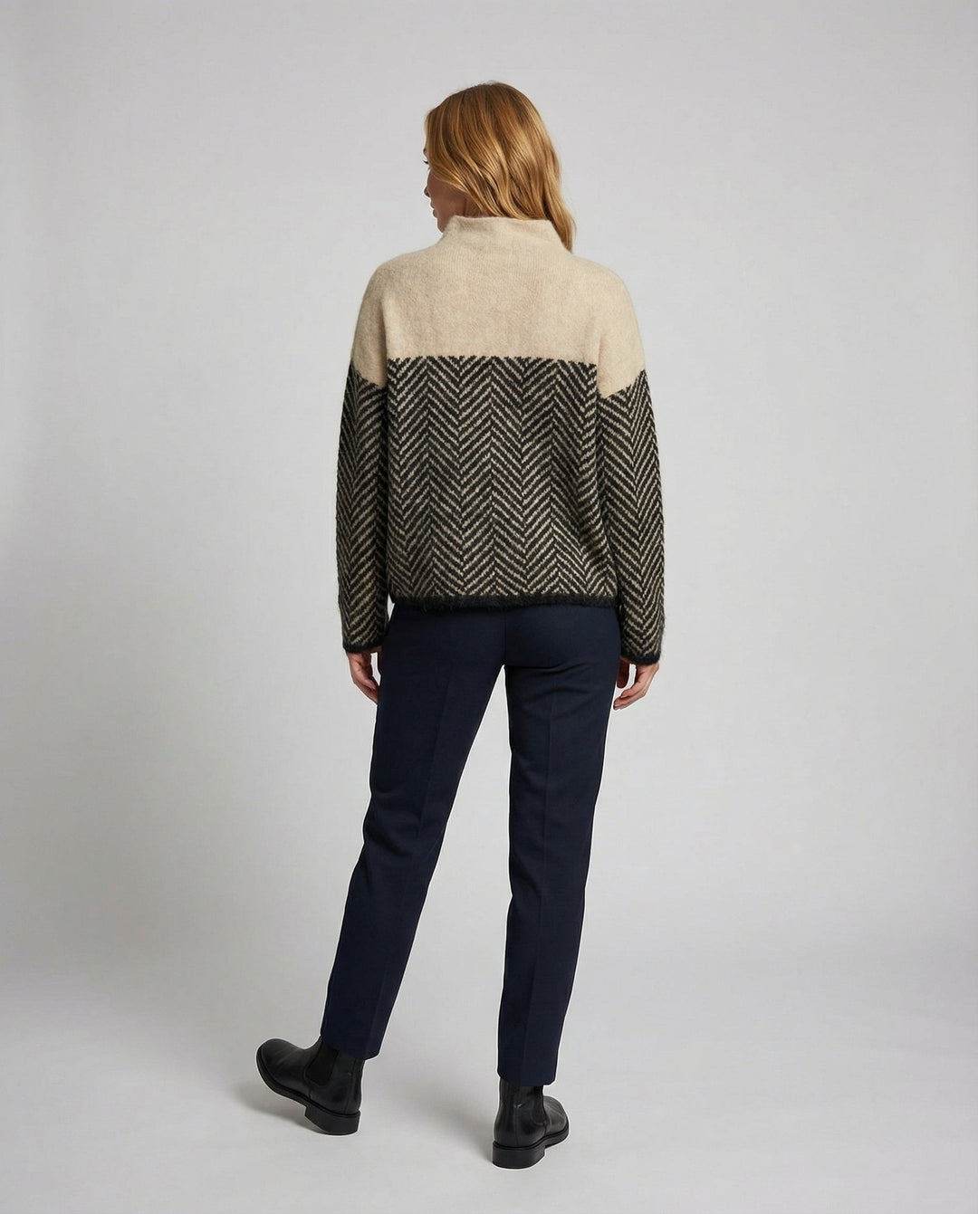 Close-up of a women's cozy textured turtleneck sweater, showcasing its warmth and elegant style.