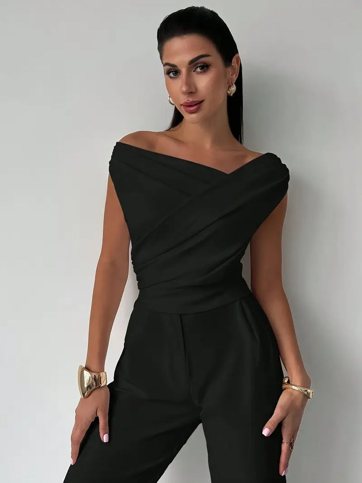 Sleek black women's draped shoulder top, offering minimalist elegance for any setting.