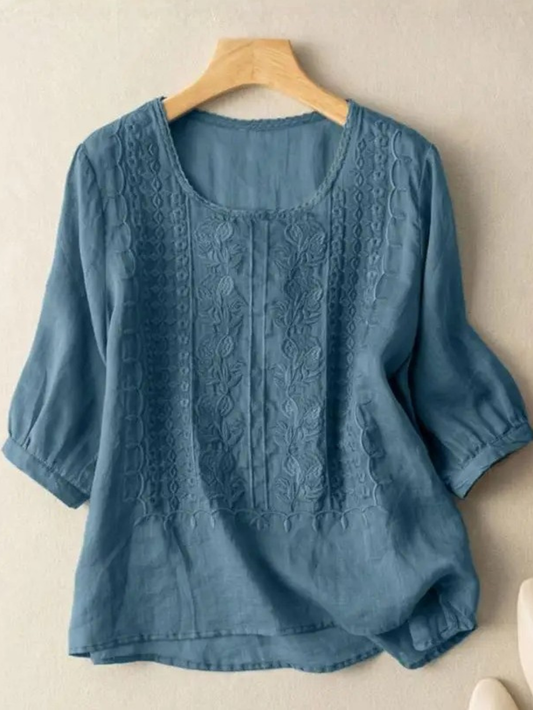 Intricate embroidery detail on a women's long sleeve relaxed fit blouse. Elegant, feminine, and modern style.