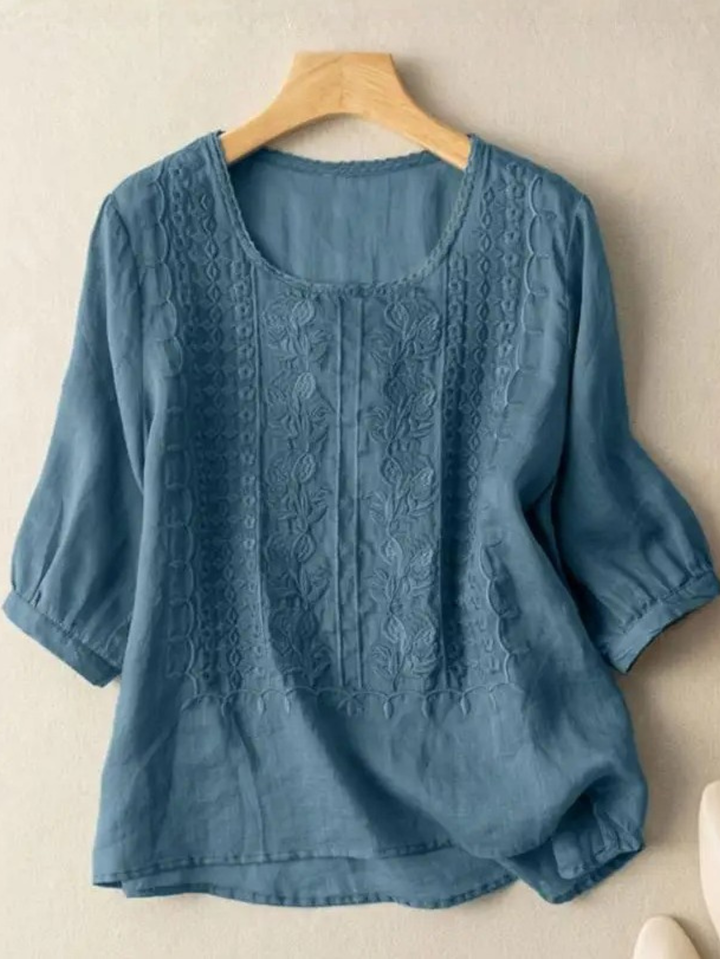 Intricate embroidery detail on a women's long sleeve relaxed fit blouse. Elegant, feminine, and modern style.