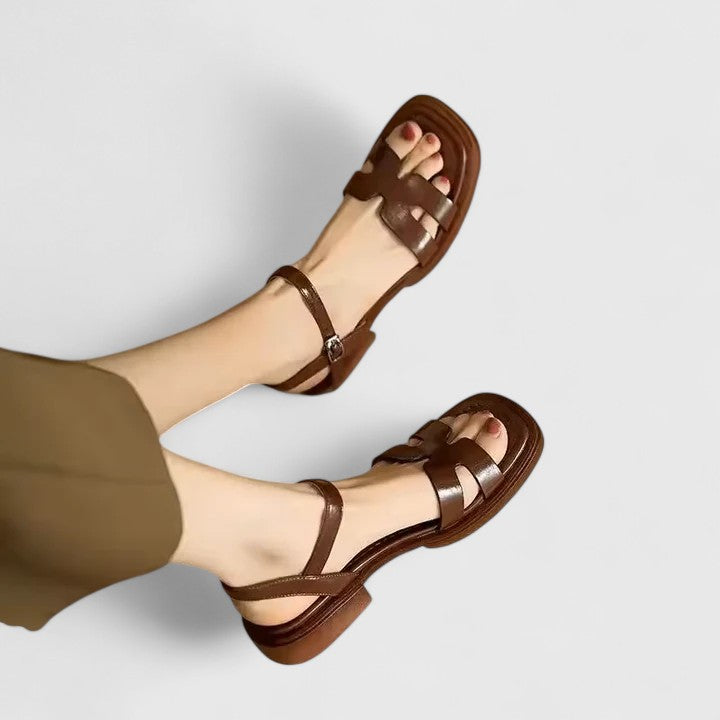 Stylish women's flat sandals featuring an adjustable ankle buckle and H-strap for comfortable elegant summer wear.